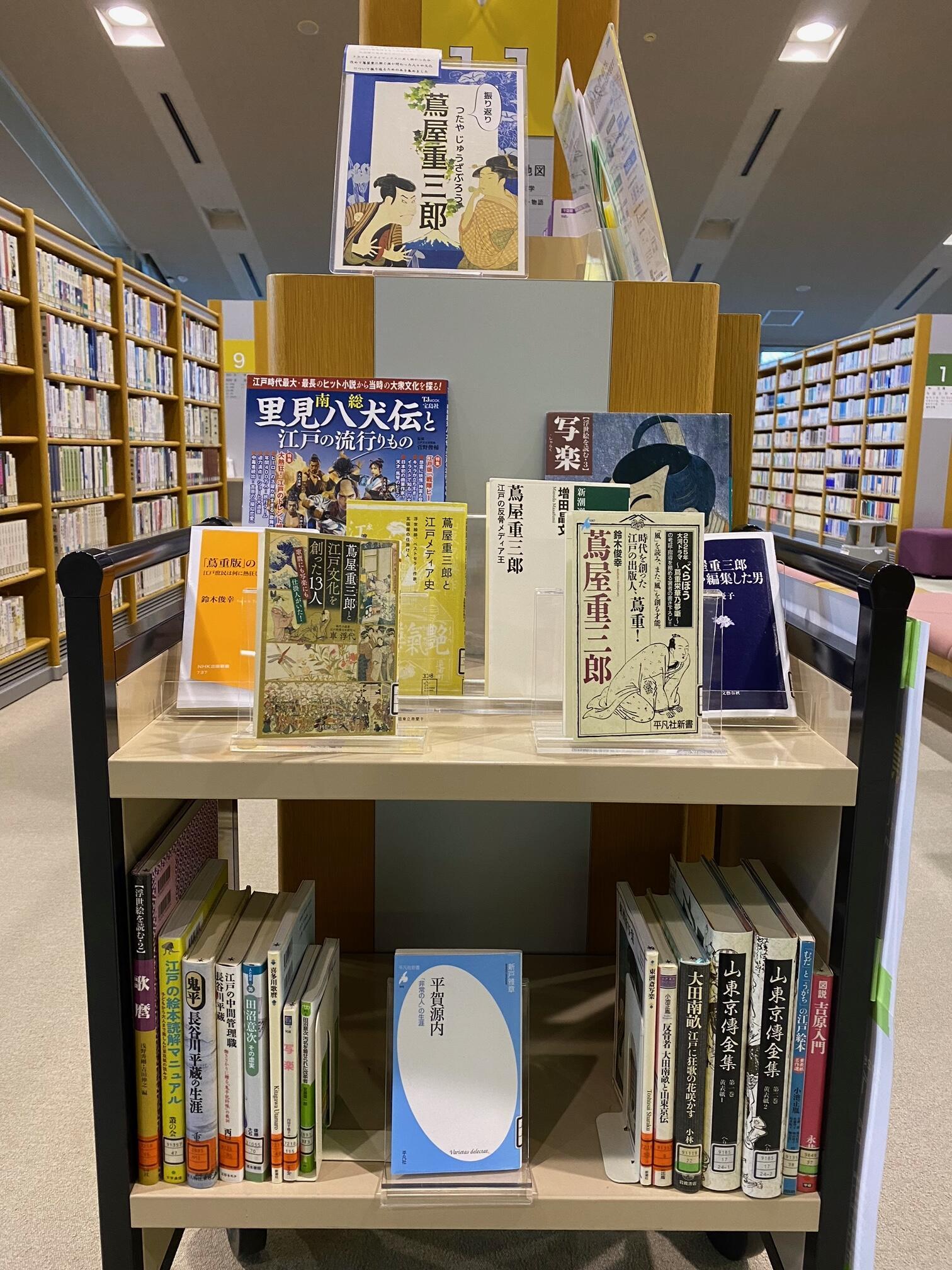 「振り返り　蔦屋重三郎」展示風景。ブックトラックに関連図書が並べられている。